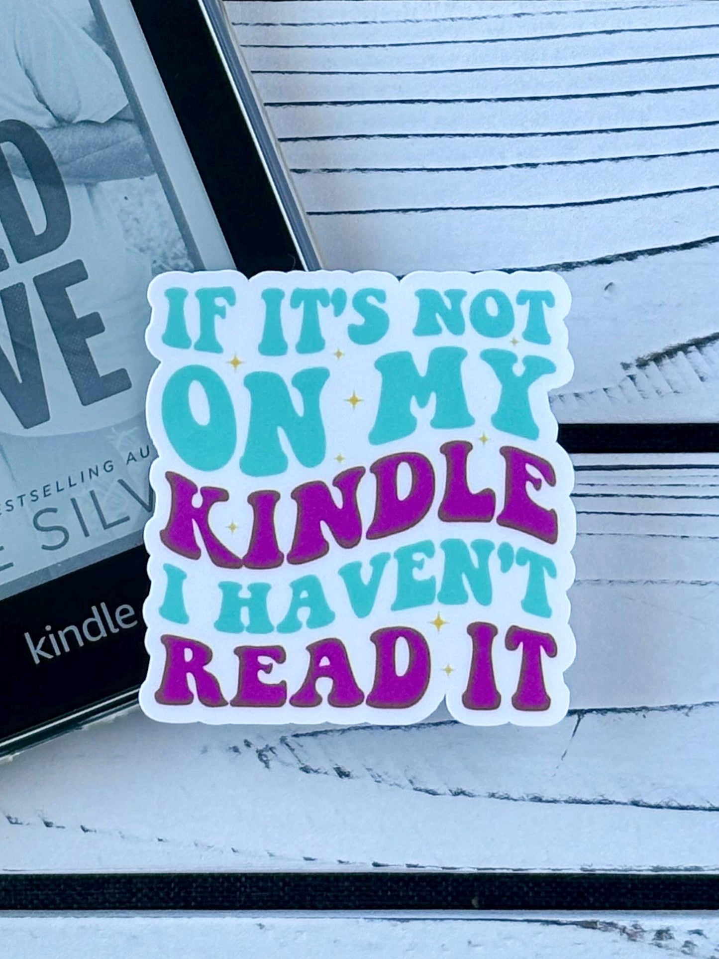 Sticker that says ‘If It’s Not on My Kindle I Haven’t Read It’ in colorful retro text on a white background