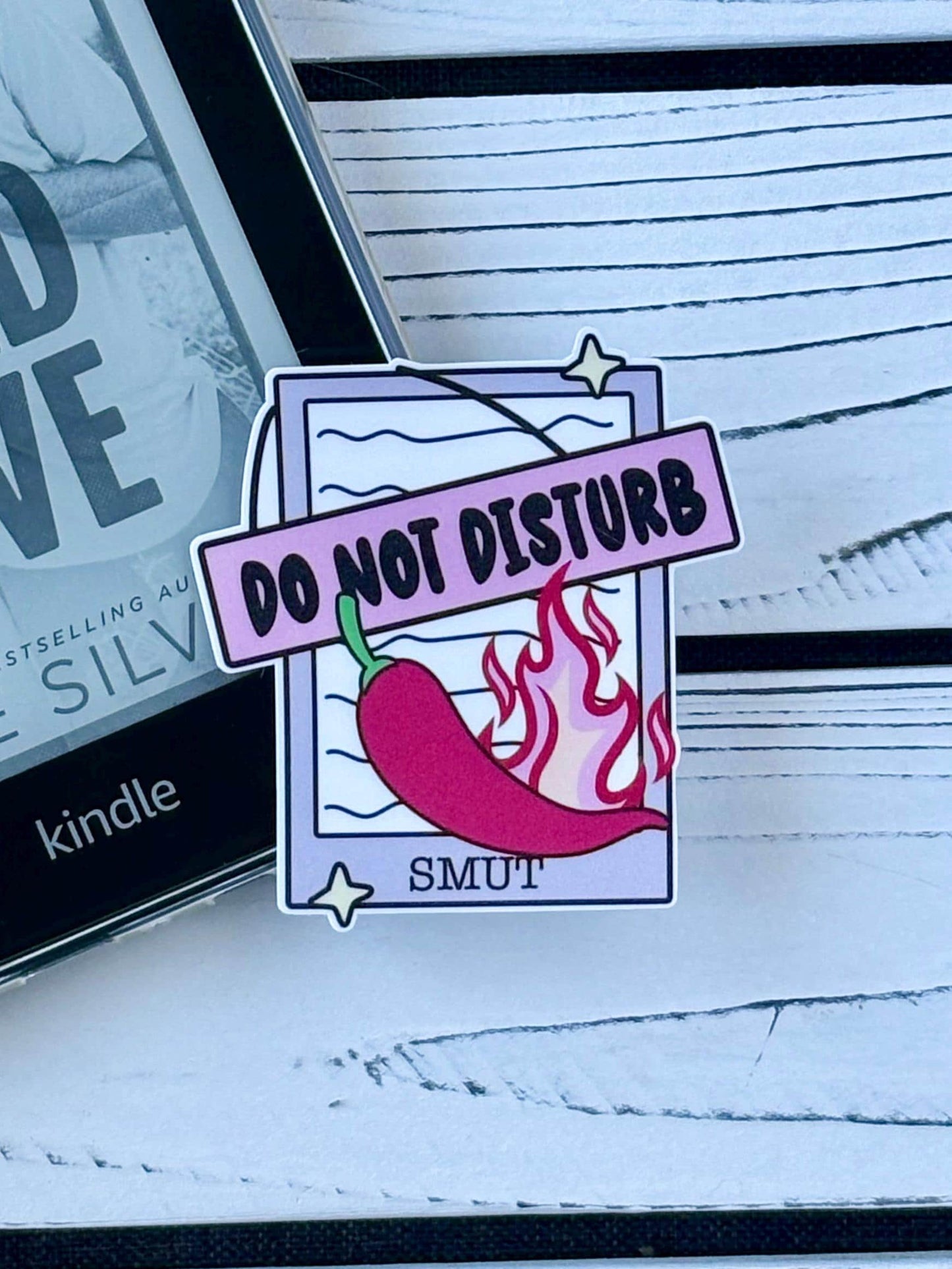 Sticker that says ‘Do Not Disturb: Smut’ in bold text on a Kindle