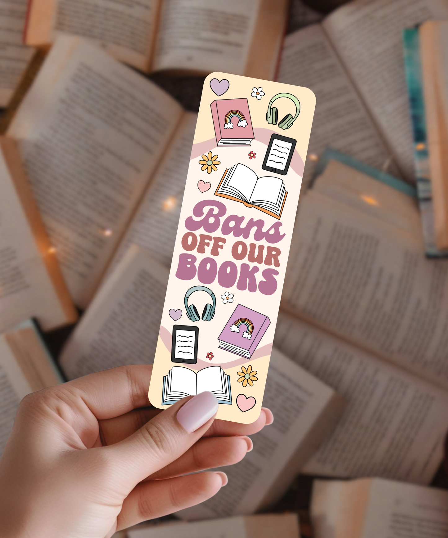 Hand holding a colorful bookmark with text and illustrations on a background of open books.