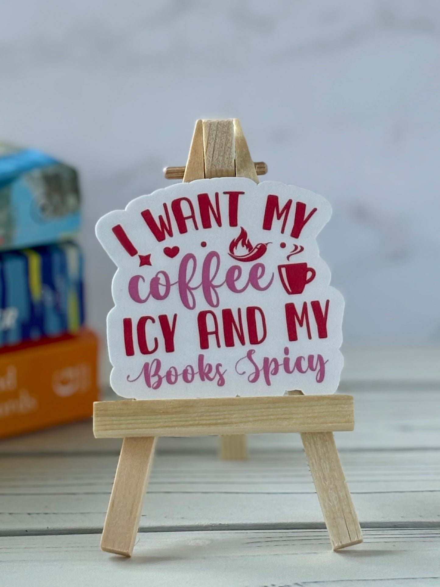Retro pink and red text sticker that says “I Want My Coffee Icy and My Books Spicy” in playful fonts