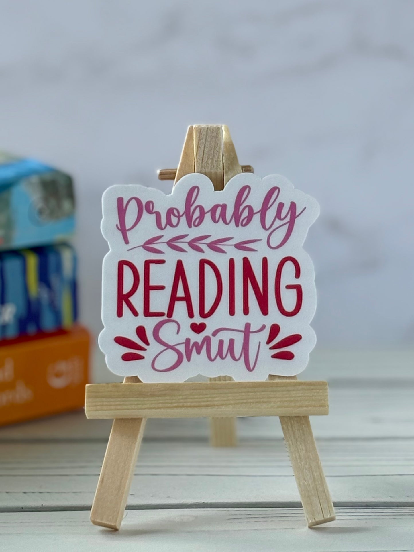 Pink and red retro text sticker reading “Probably Reading Smut” with heart and leaf accents