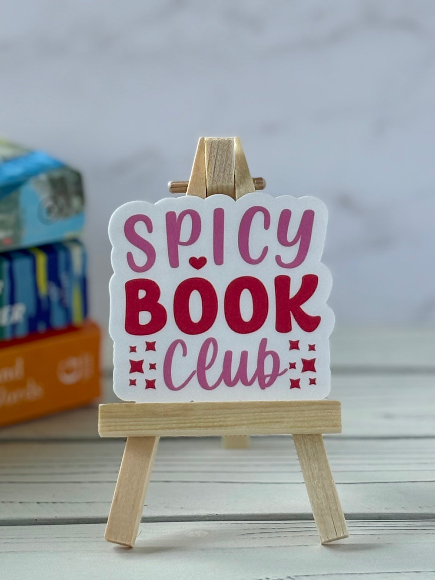 Retro pink and red text sticker saying “Spicy Book Club” with heart and star accents.