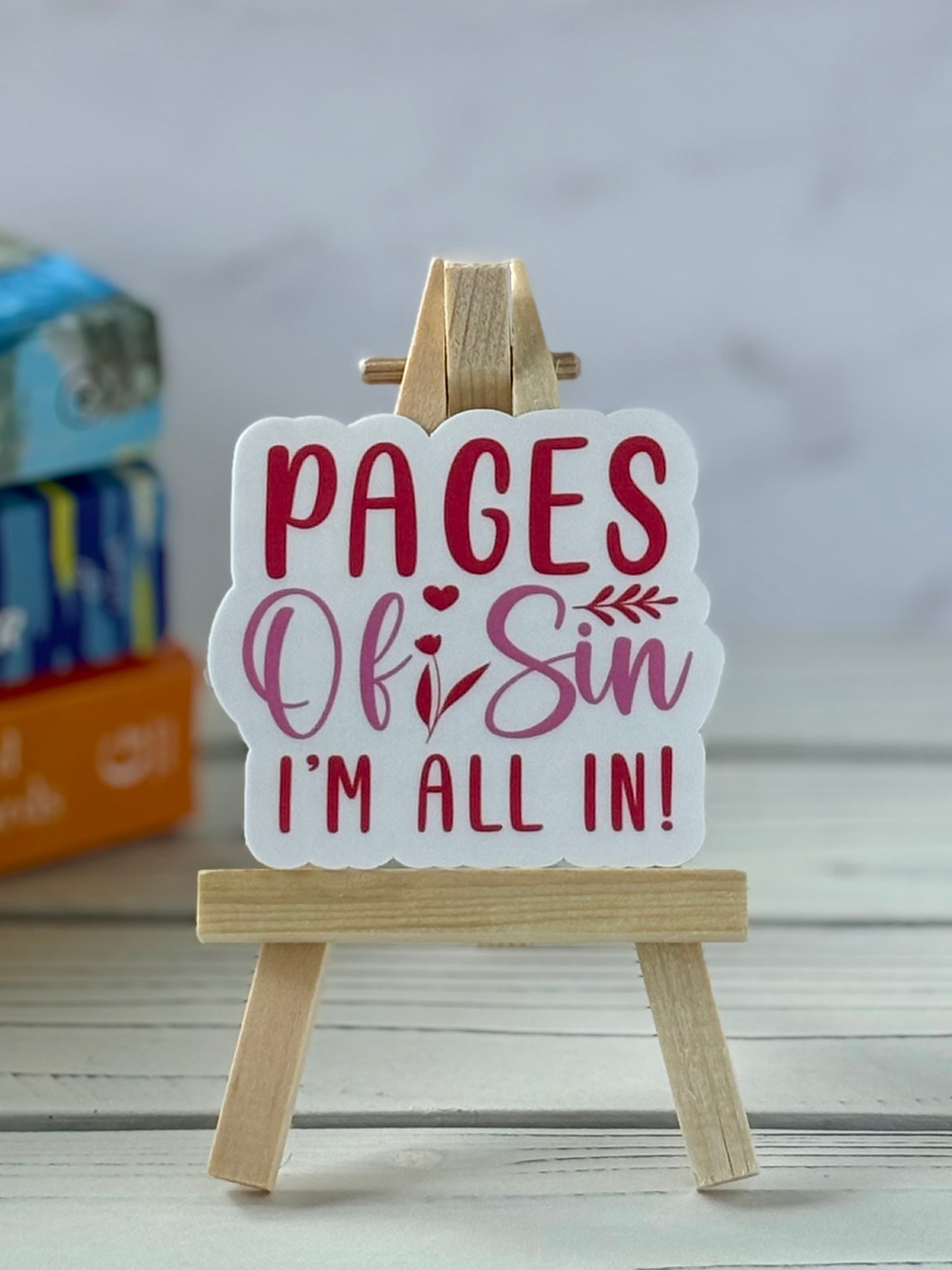 Retro text sticker reading “Pages of Sin I’m All In” in pink and red with playful accents.