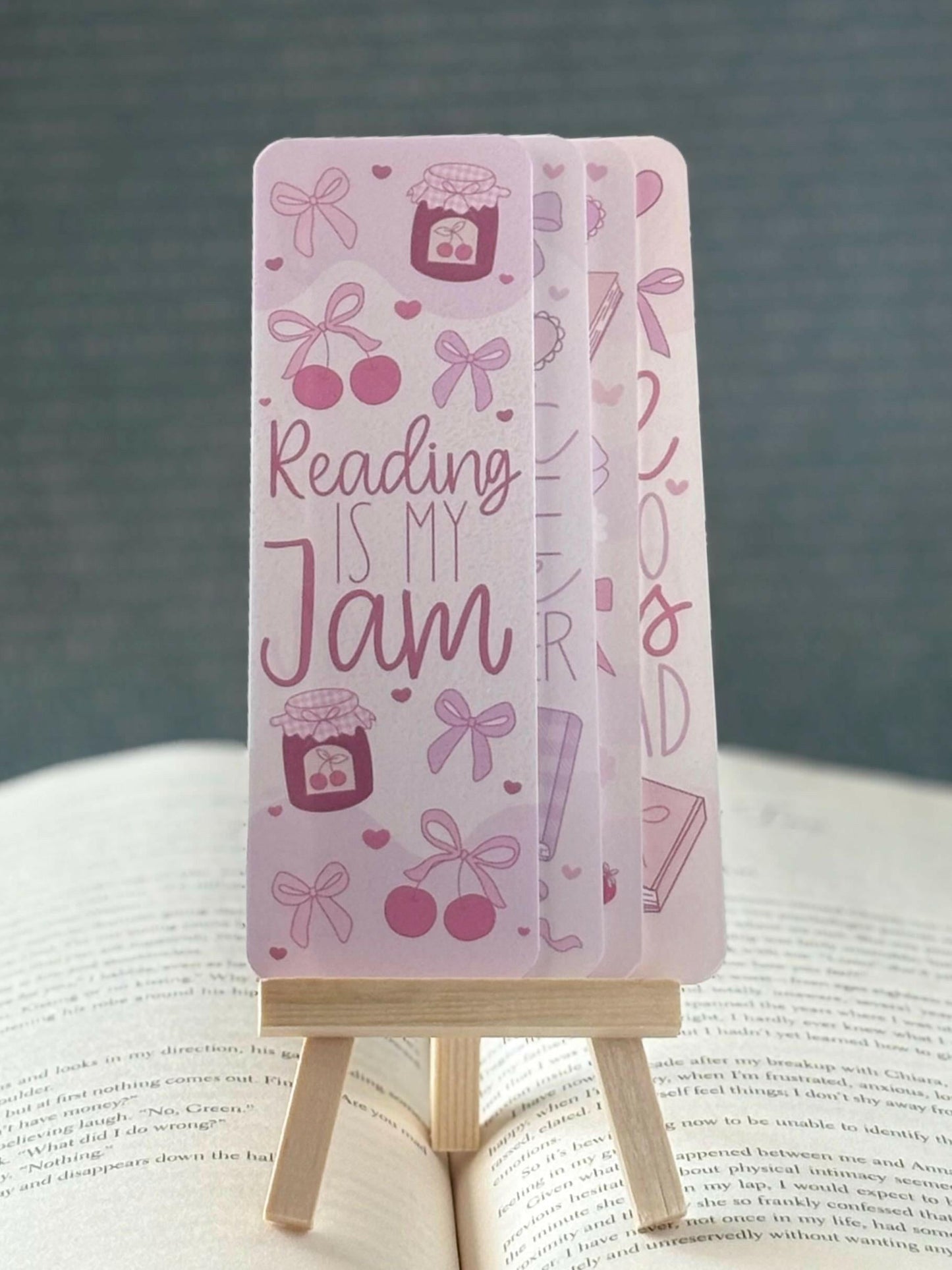 Coquette-core bookmark set with pink bows, cherries, strawberries, and hearts. Includes book-themed quotes and soft girl aesthetic.