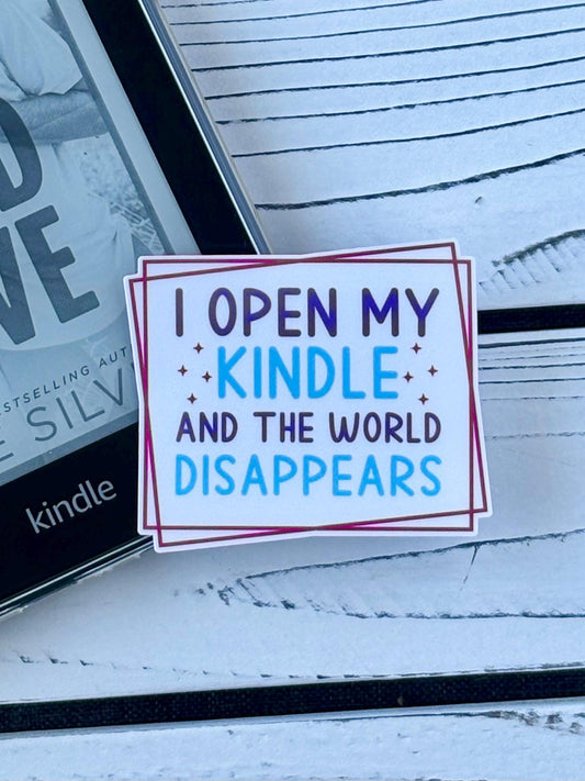 Sticker that says ‘I Open My Kindle and the World Disappears’ in retro-style text on a white background