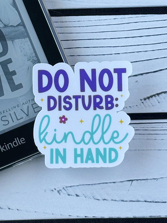 Sticker that says Do Not Disturb: Kindle in Hand’ in bold retro lettering on a white background