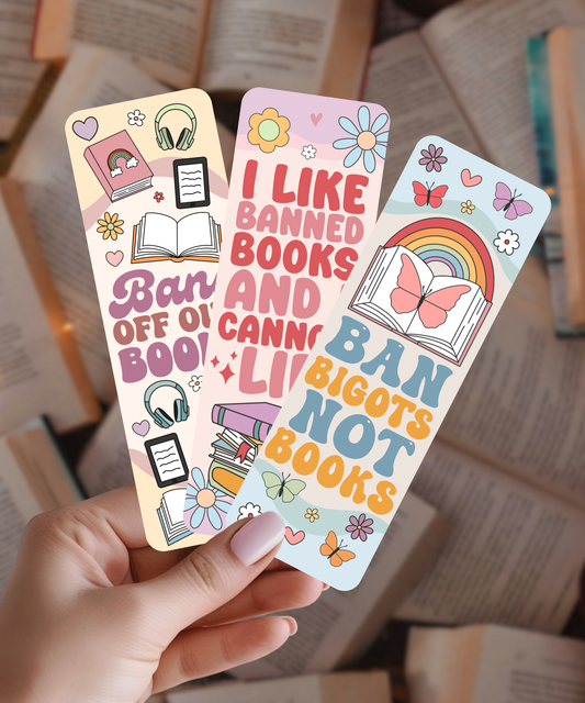 Colorful banned books bookmarks held by a hand with books in the background