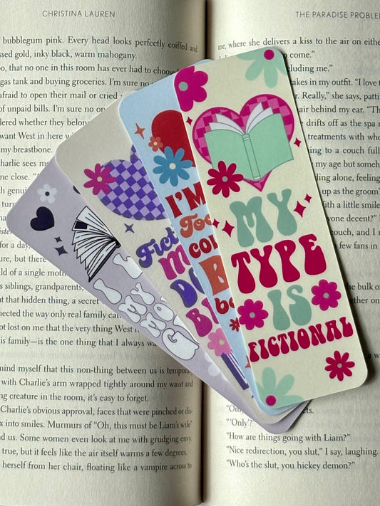 Retro romance bookmark bundle with four colorful designs featuring hearts, checkerboard print, flowers, and books. Includes sayings: My Type Is Fictional, I’m Way Too Busy Collecting Book Boyfriends, I Like My Men Morally Gray, Fictional Men Do It Better.