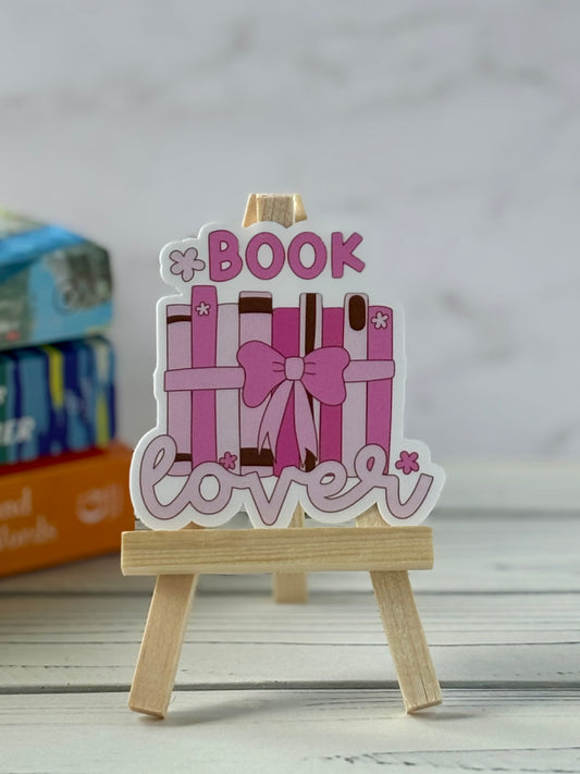 Decorative sign with 'Book Lover' text on a wooden stand against a blurred background