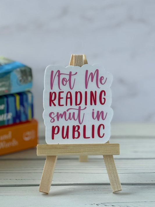 Pink and red retro sticker that says “Not Me Reading Smut in Public”