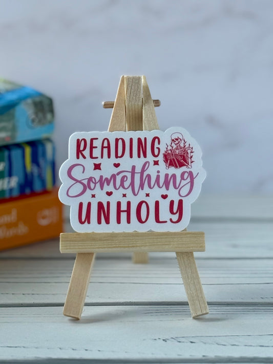 Retro pink and red text sticker saying “Reading Something Unholy.”