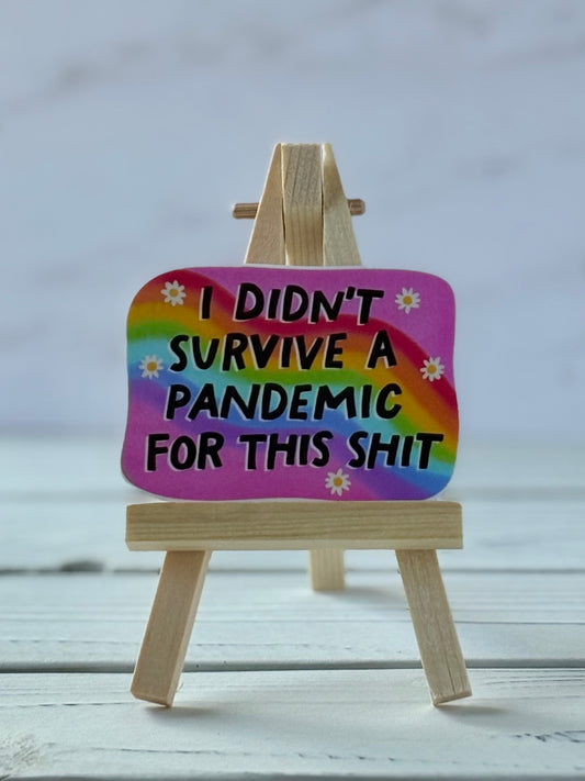 Pink sticker with rainbow, daisies, and black text reading “I Didn’t Survive a Pandemic for This Shit”