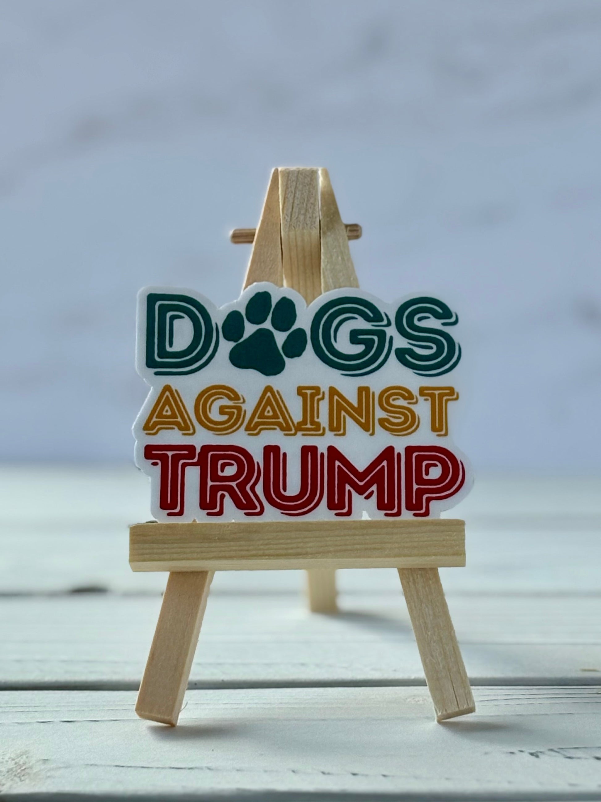Dogs Against Trump protest sticker in bold typography, jewel-tone colors, Snark for Social Change collection. 
