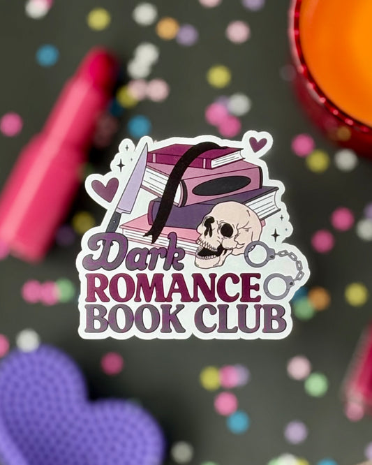 Sticker design featuring a purple book stack with skull, knife, handcuffs, and hearts. Text reads “Dark Romance Book Club.”