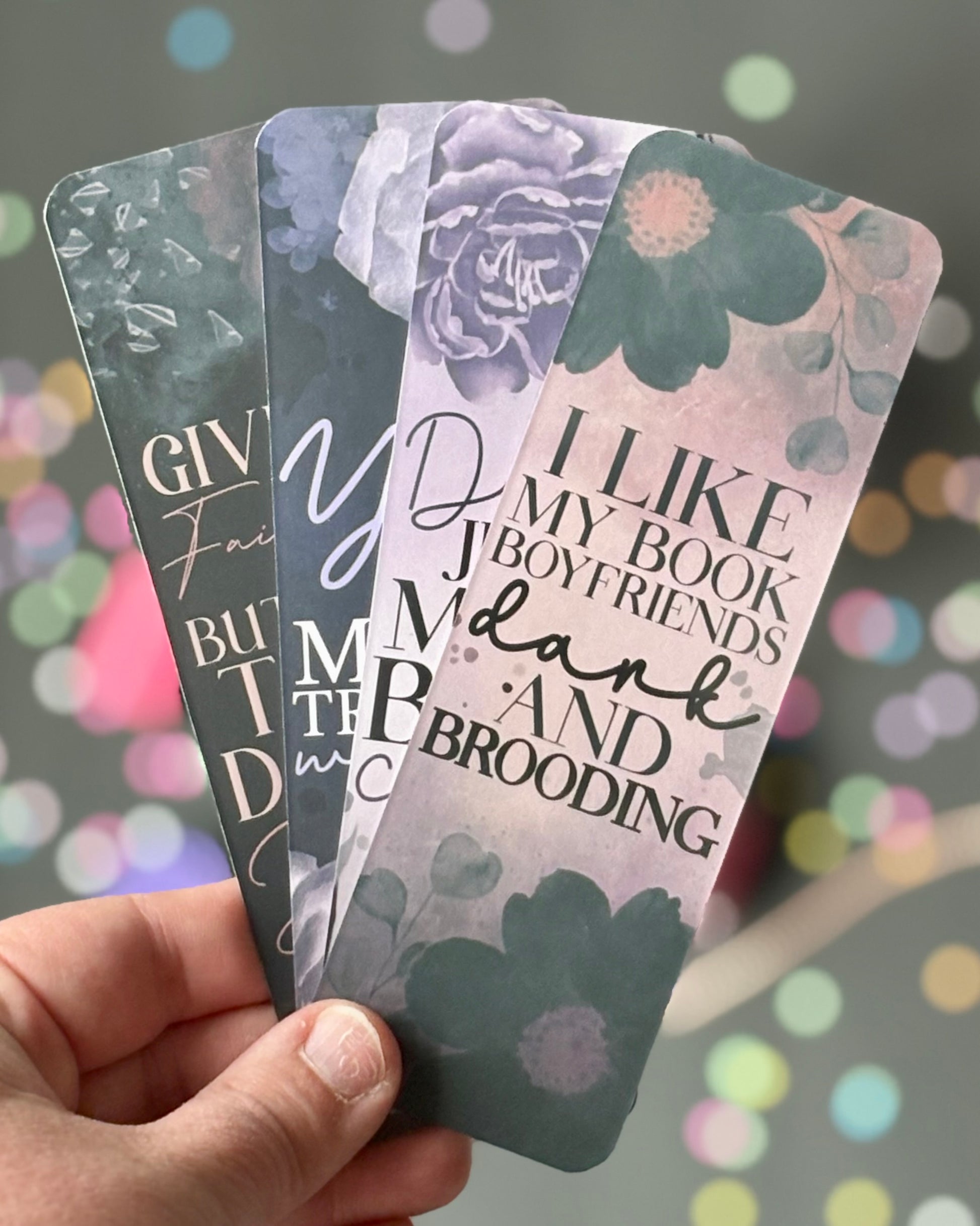 Set of 4 bookmarks in dark purples, blacks, and grays with quotes referencing spicy fairytales and dark romance tropes.
