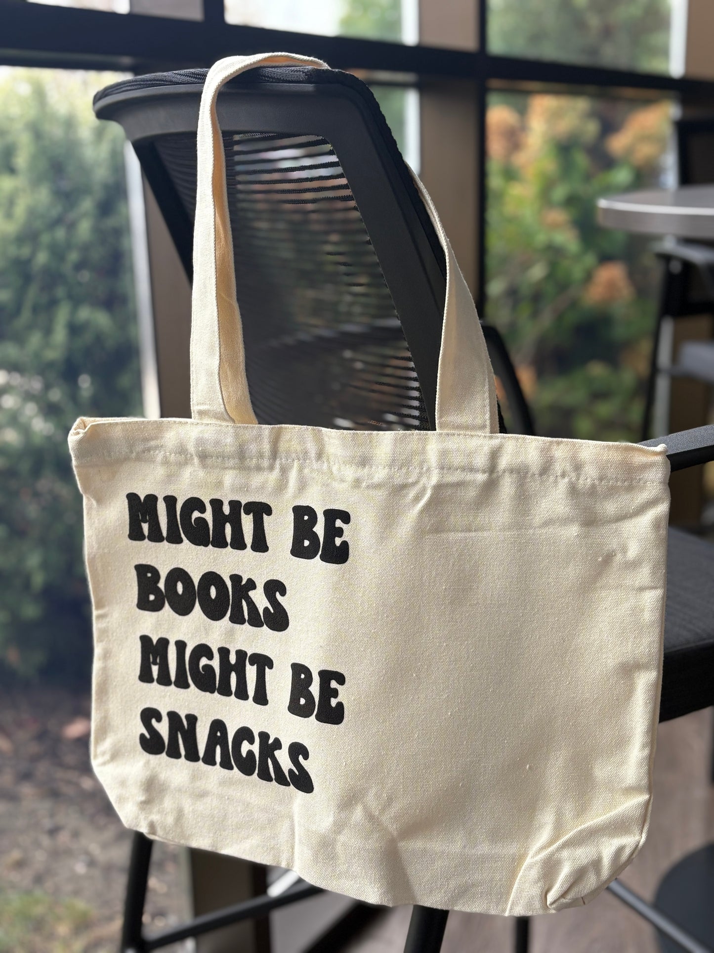 Cute bookish tote that says Might Be Books Might Be Snacks