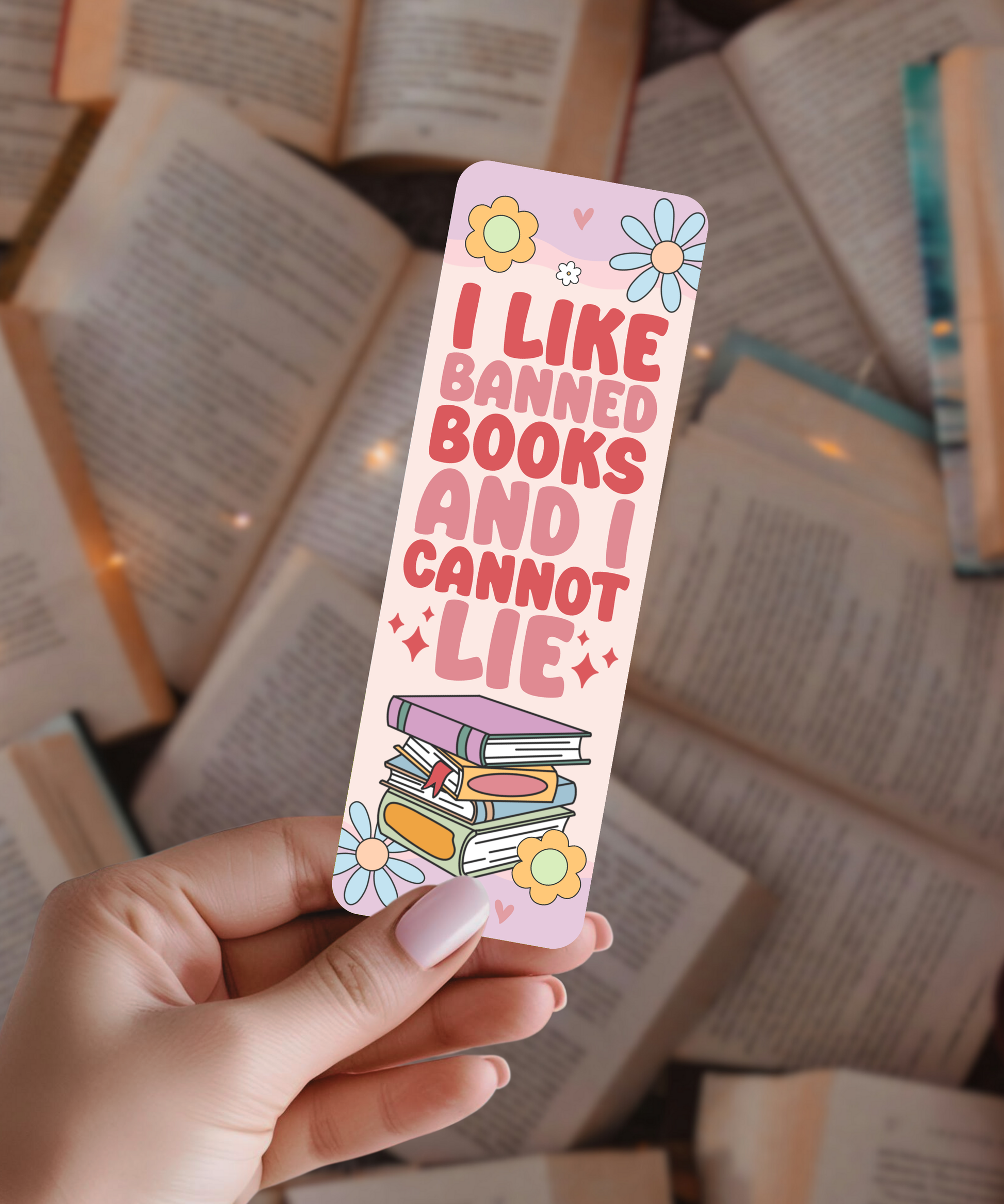 Hand holding a colorful bookmark with text and illustrations on a background of open books.