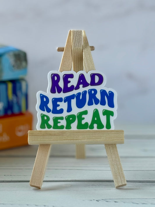 Small wooden easel with 'Read Return Repeat' retro vinyl sticker on a light background