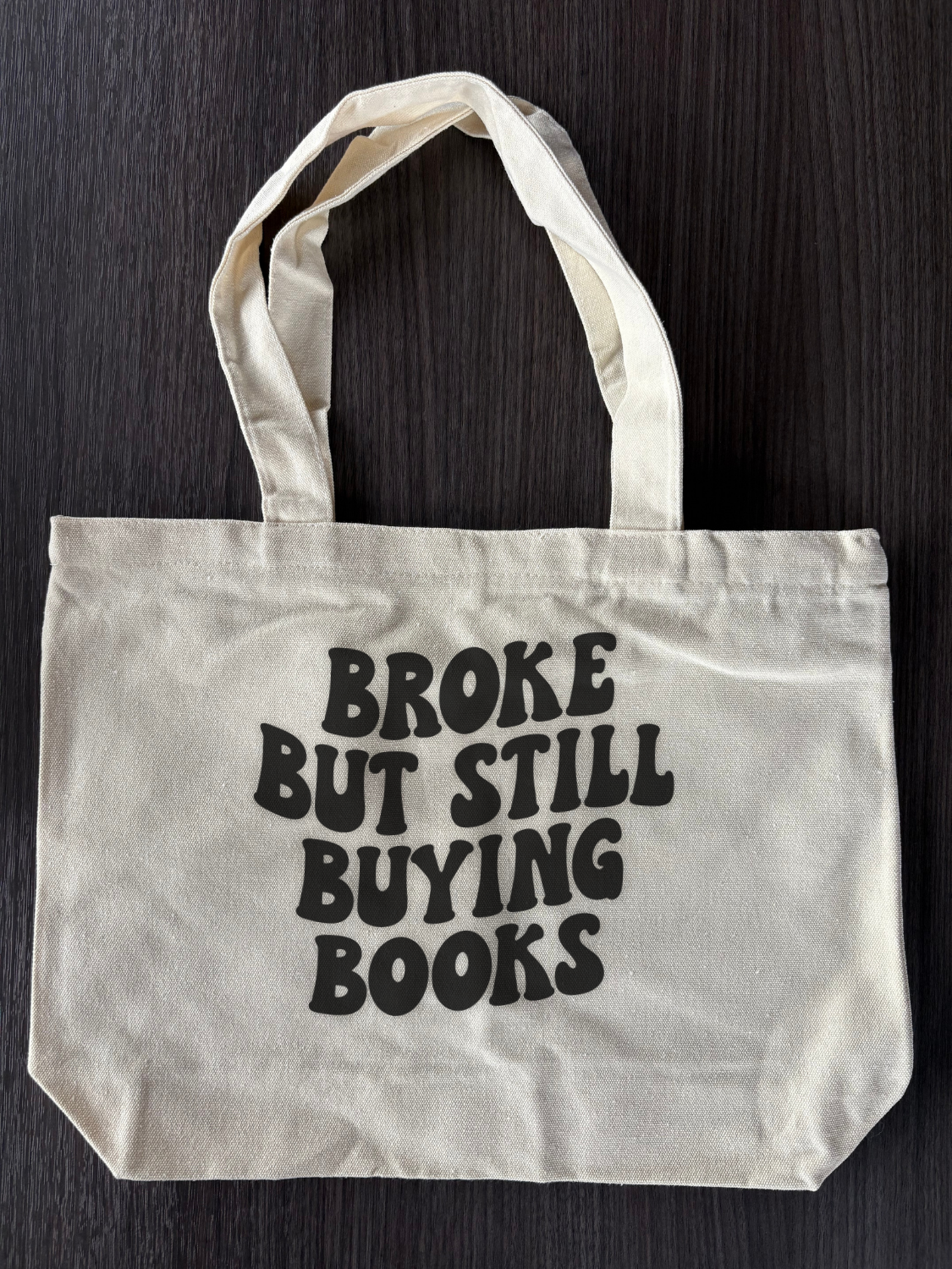 Flat lay of Cute Bookish Tote Bag - Broke But Still Buying Books Bag